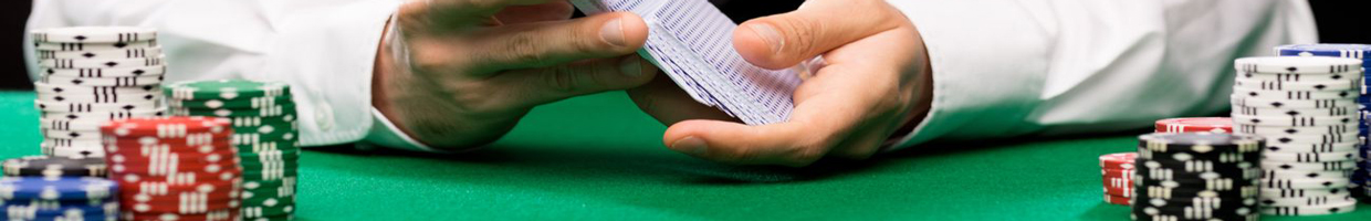Man in smart clothes shuffling cards on a table with poker chips