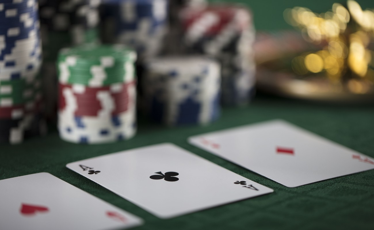 Concept of a poker game with playing cards and poker chips on a table.