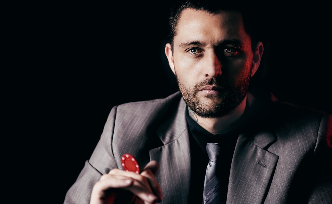 Frustrated poker player with chip in hand 