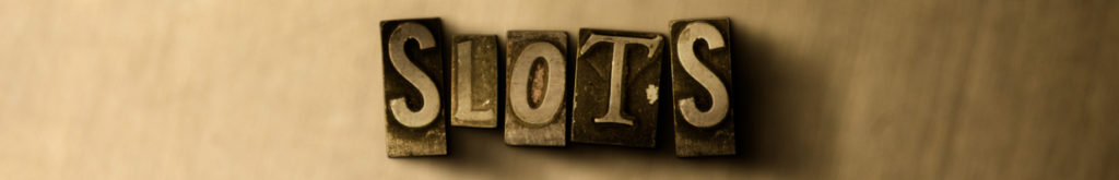 close-up of grungy vintage typeset word saying "slot" on metal backdrop
