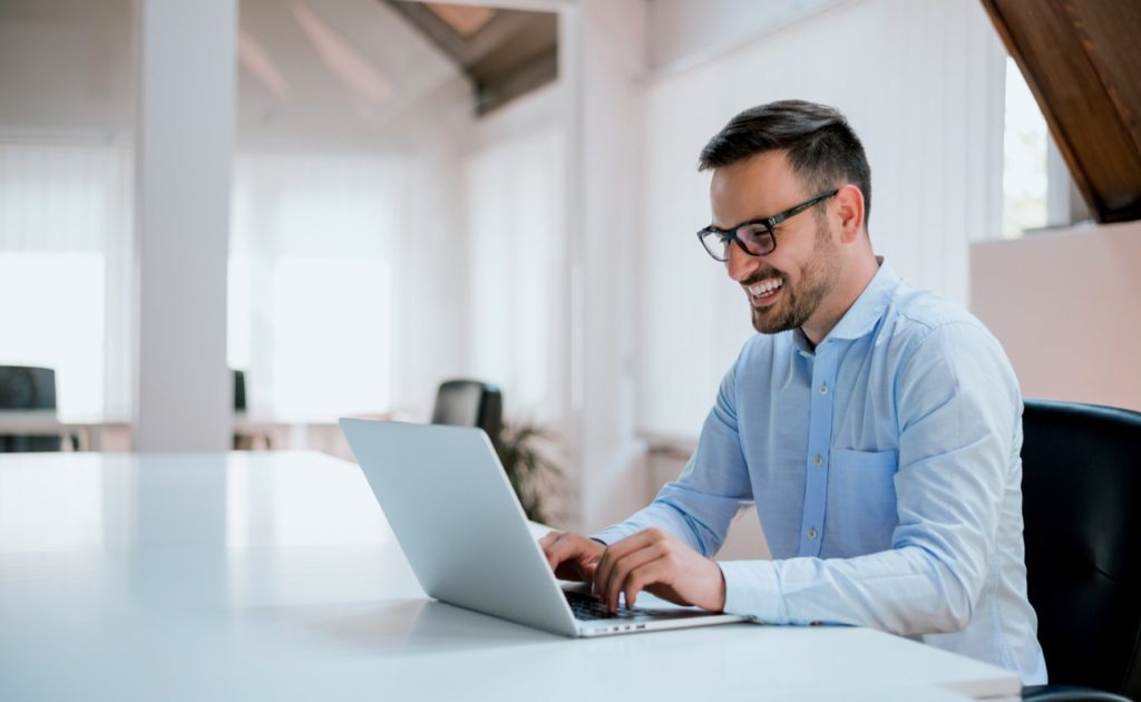 Young man sitting at his desk in the office on laptop