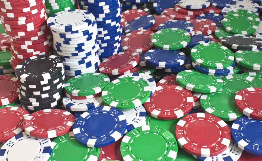 Various color poker chips stacked and scattered across a table