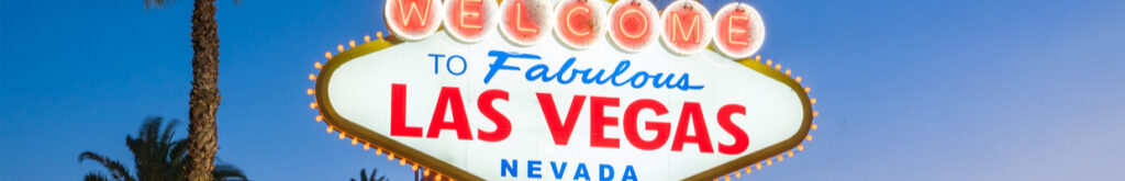 A Welcome to Las Vegas sign with palm trees in the background.