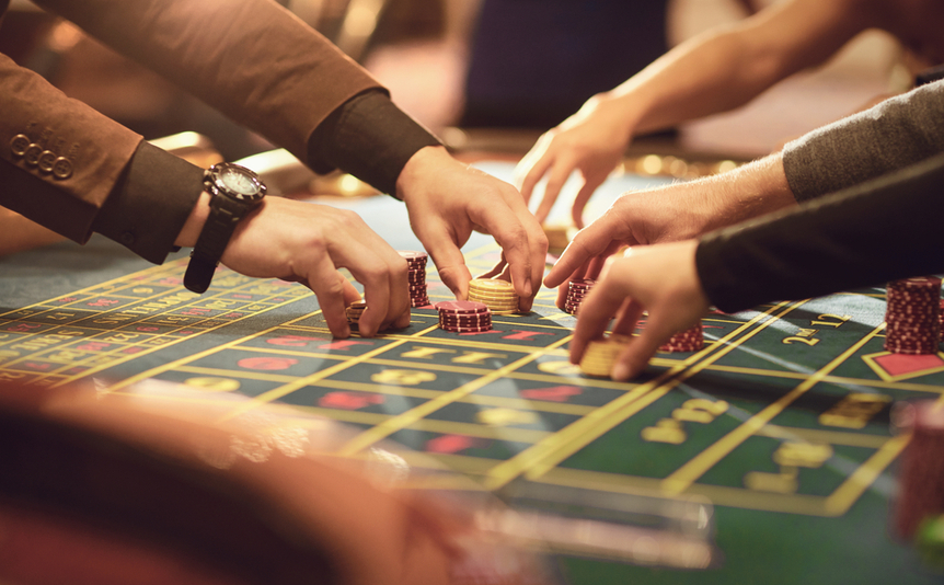 A close-up of people placing chips on a roulette table.