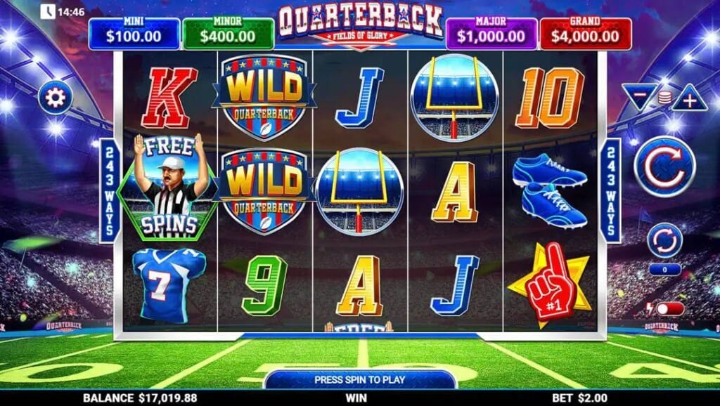 A screenshot of the slot reels in Quarterback Fields of Glory. The backdrop is a packed football stadium at dusk with the stadium lights on. The slot reels contain a mix of football-themed symbols and playing card symbols. 
