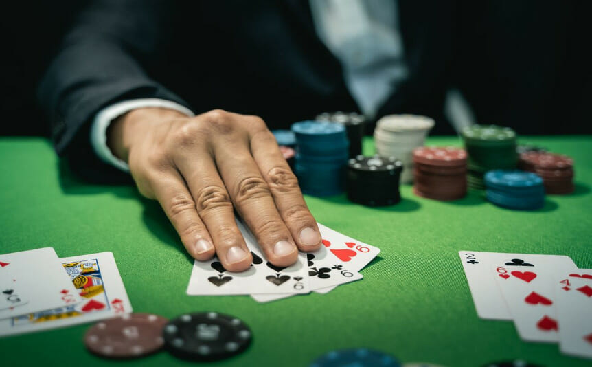 A man covers his poker cards with his fingers.