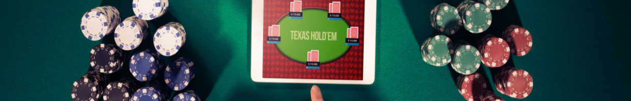 Aerial view of a person playing online poker on a tablet with chips next to them.