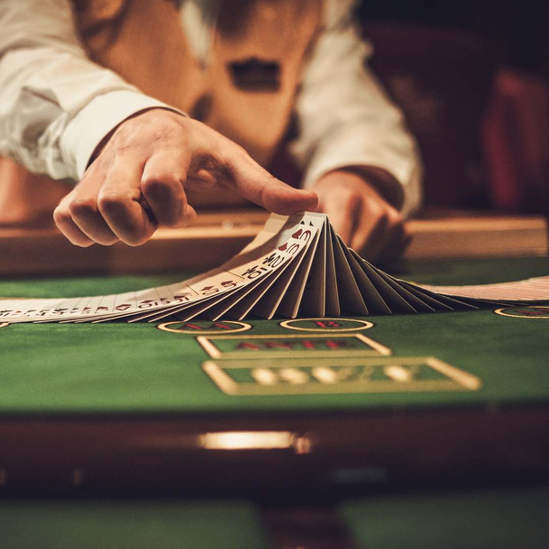 A dealer flips cards on a poker table