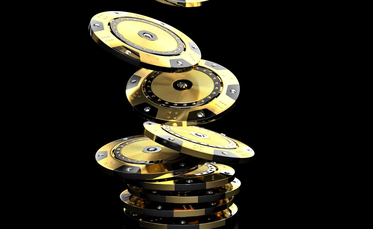 Black and gold poker chips against black background.