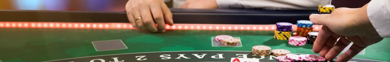 A dealer taking a blackjack player’s bet.