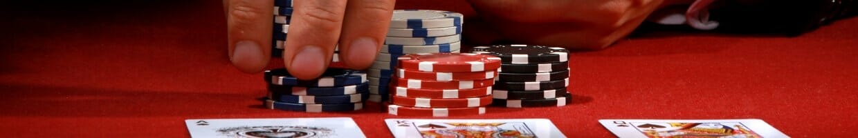 A poker player picks up chips to place their bet.