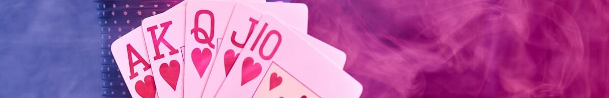 A royal flush leaning against stacks of poker chips in a smoky room.