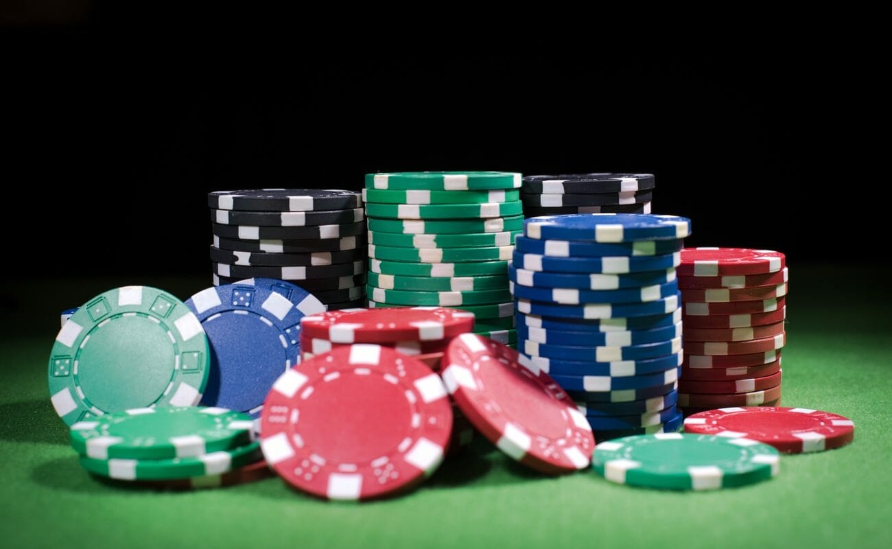 Several stacks of poker chips are surrounded by scattered poker chips.