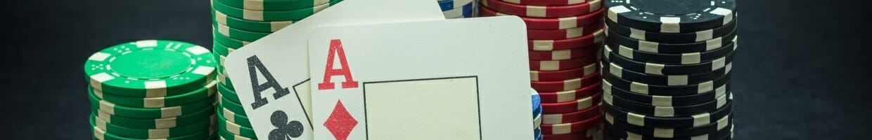 Two aces lean against stacks of poker chips.