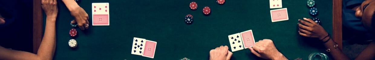 Hero image, top view of friends sitting around a poker table playing poker