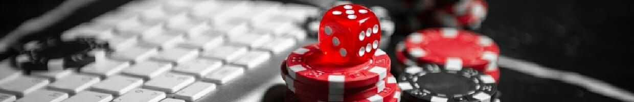 Dice and poker chips next to a keyboard