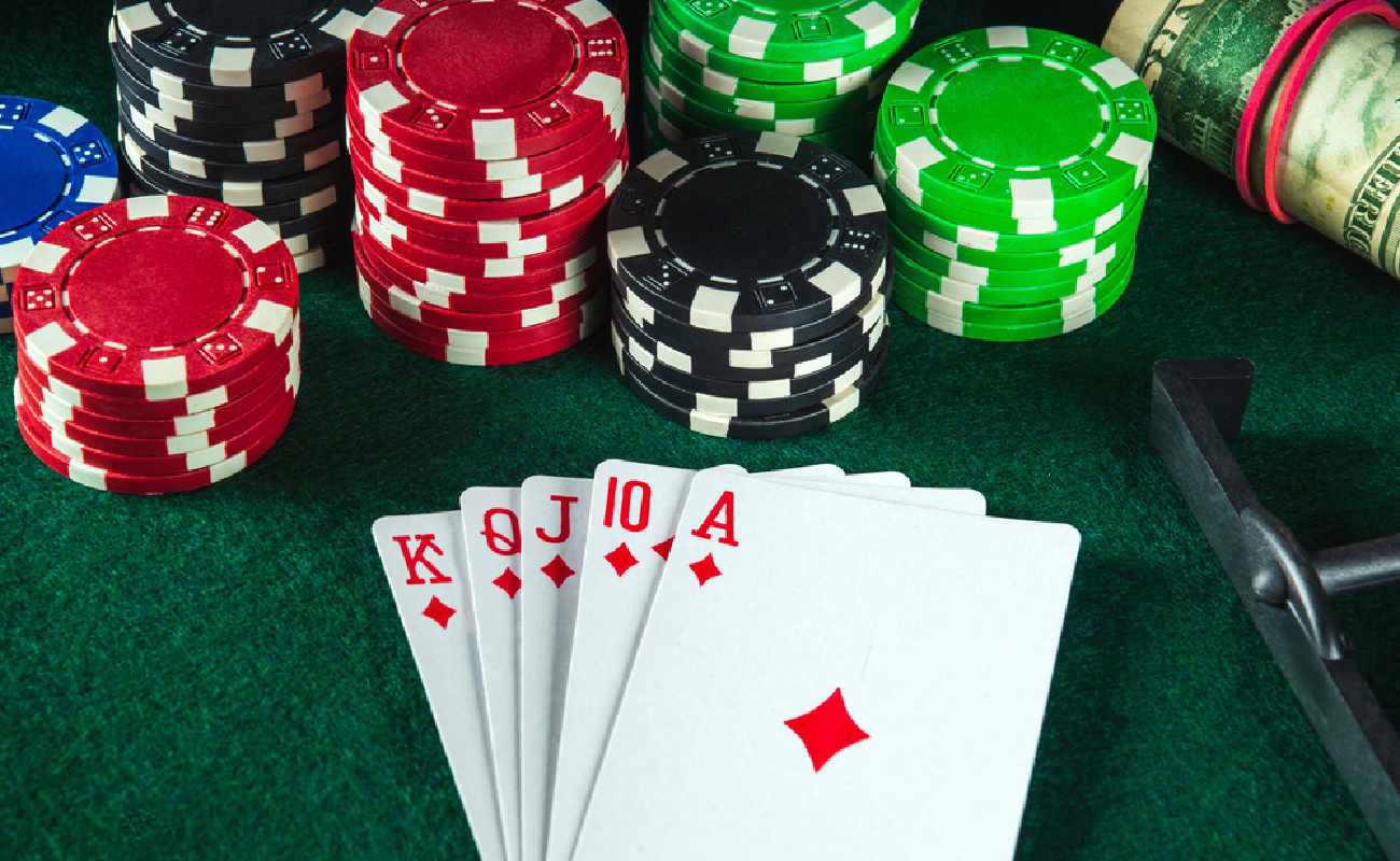 A royal flush hand next to some poker chips and cash