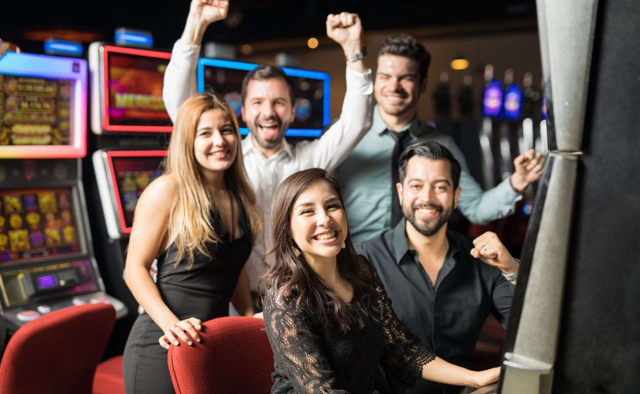  five friends celebrate a win while sitting at a slot machine in a casino