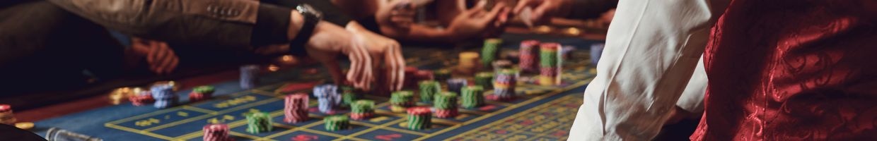 people placing bets on a roulette table in a casino