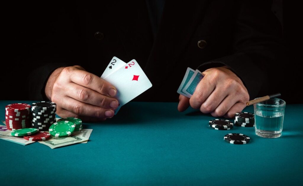 A person holding a pair of twos at the poker table