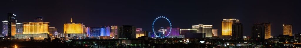 A panoramic view of the bright neon lights of the Las Vegas strip casinos at night.
