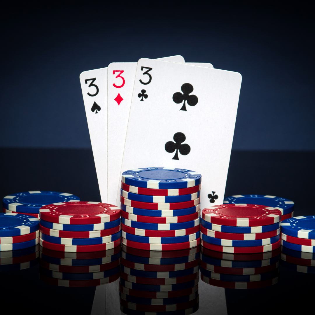 Playing cards in poker game with three of kind or set combination. Chips and cards on black table. Successful and win.