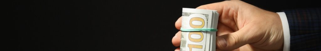 A hand holding American dollars.