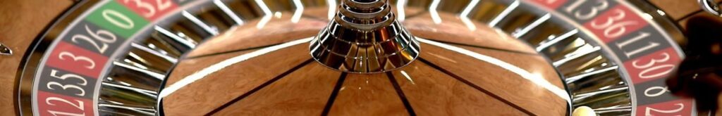 close up of a roulette wheel with a little white roulette ball in it in a casino