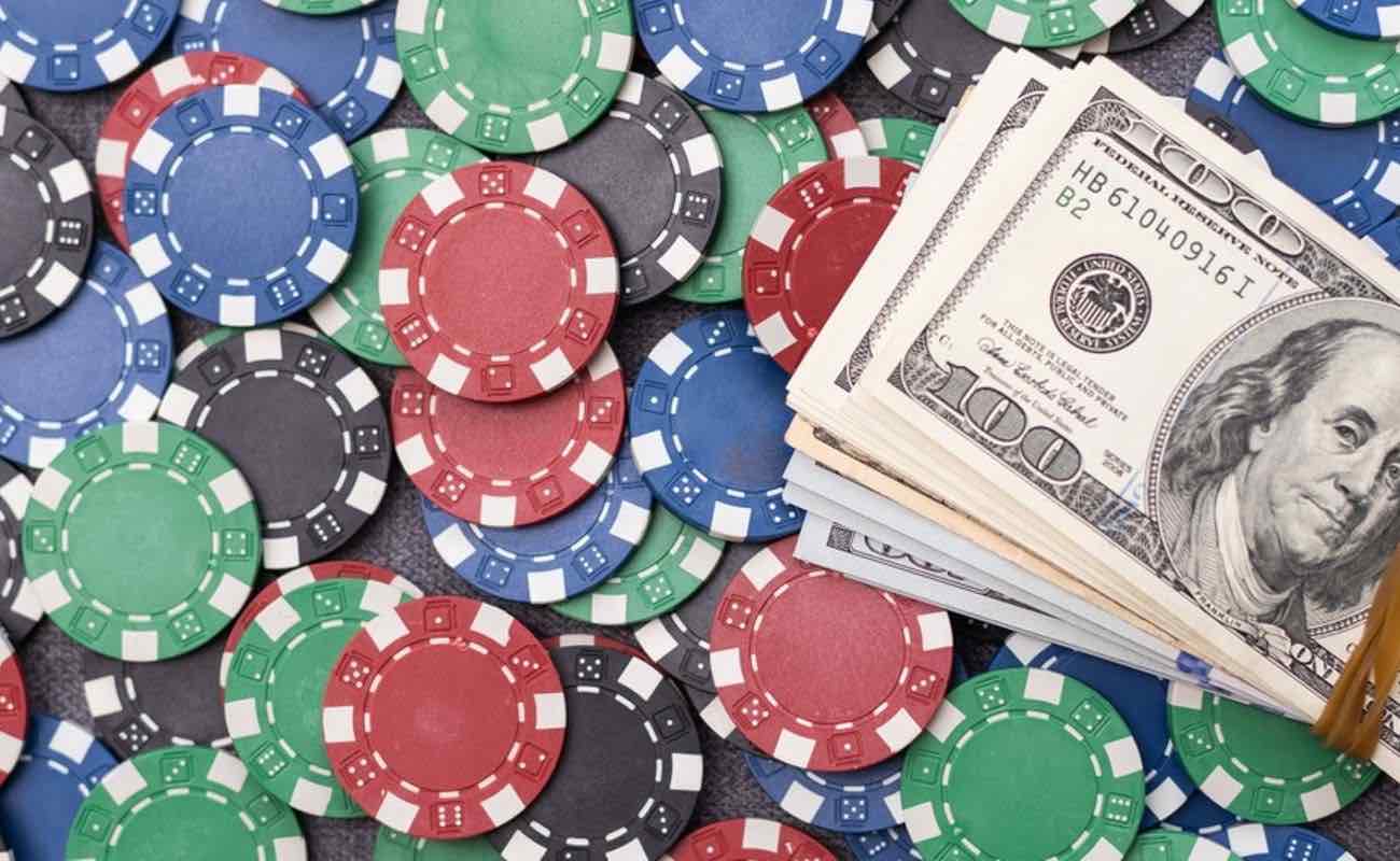 $100 bills stacked on top of colorful casino chips.