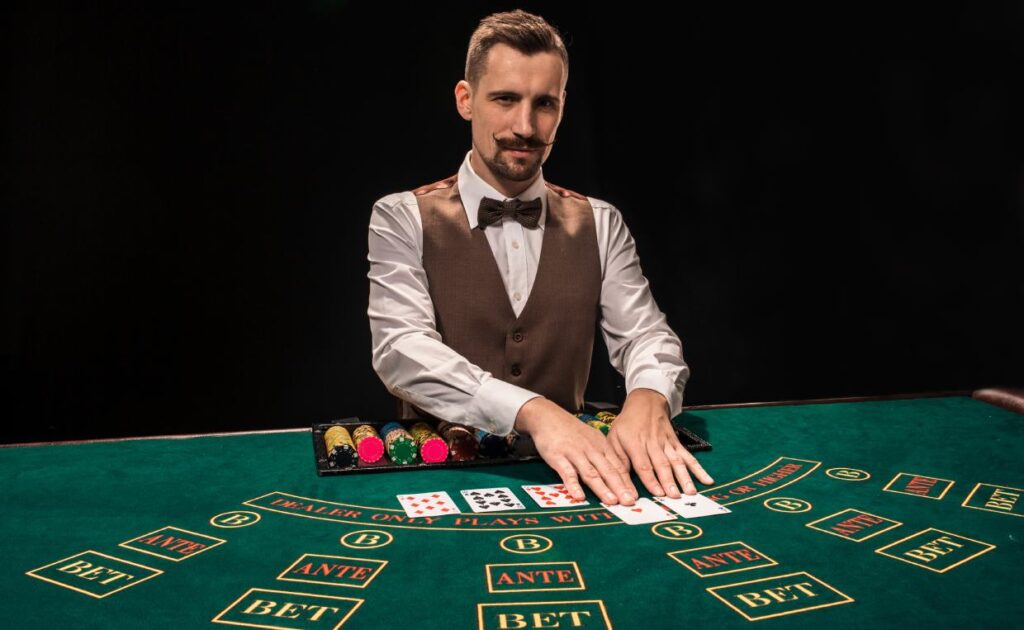 A poker dealer touches playing cards.