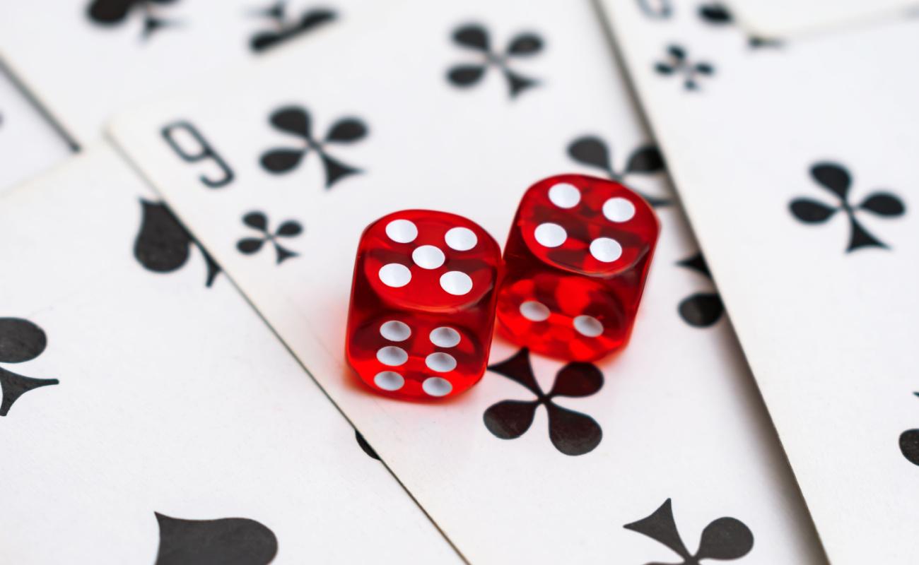 Two red dice on a nine of clubs card