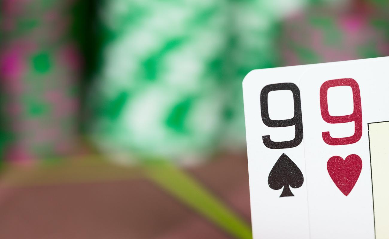 A pair of nines with poker chips in the background