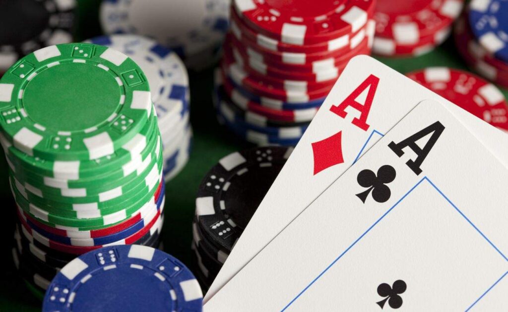 Two aces, one of diamonds and one of clubs, on top of stacks of poker chips.