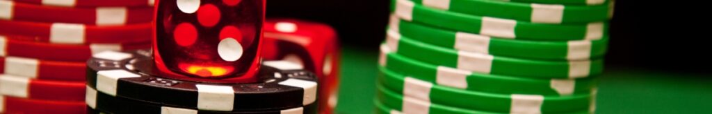 Casino chips and a die on a green felt table.