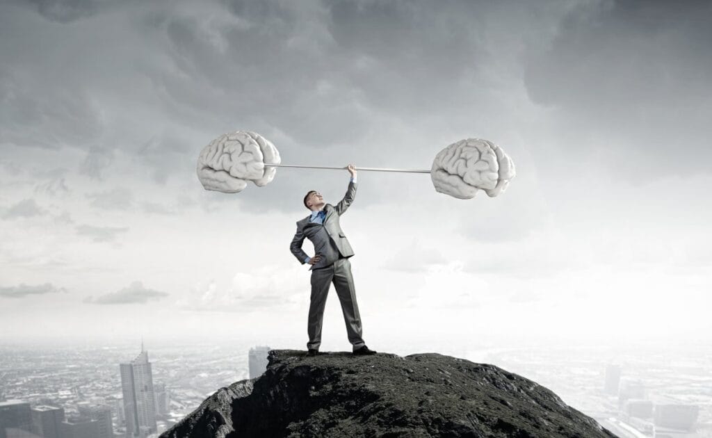 A businessman standing on a hill lifting a barbell.