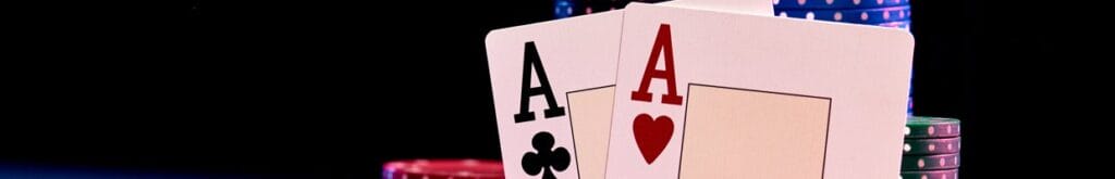 A pair of aces leaning against stacks of poker chips.