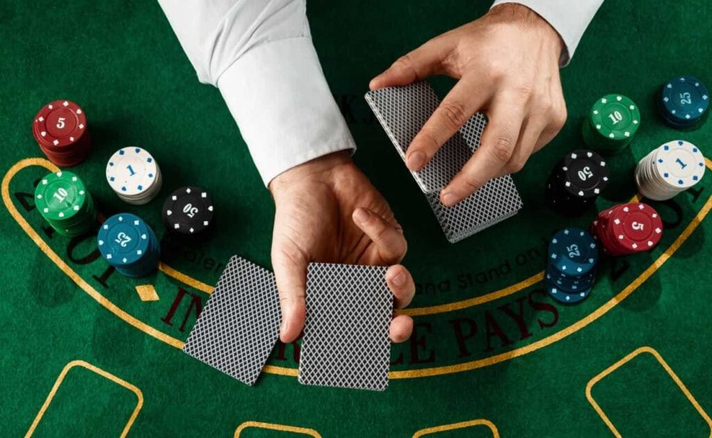 A casino dealer dealing cards on a blackjack table.