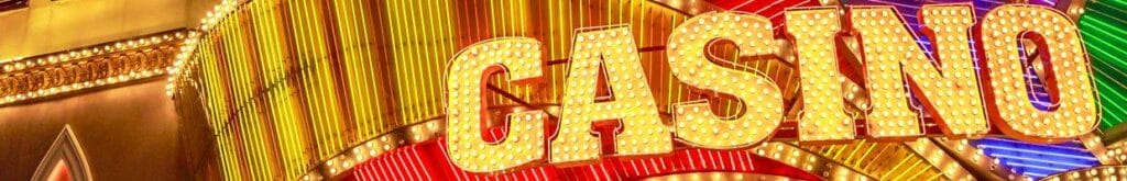 A bright casino sign outside the entrance to a casino.