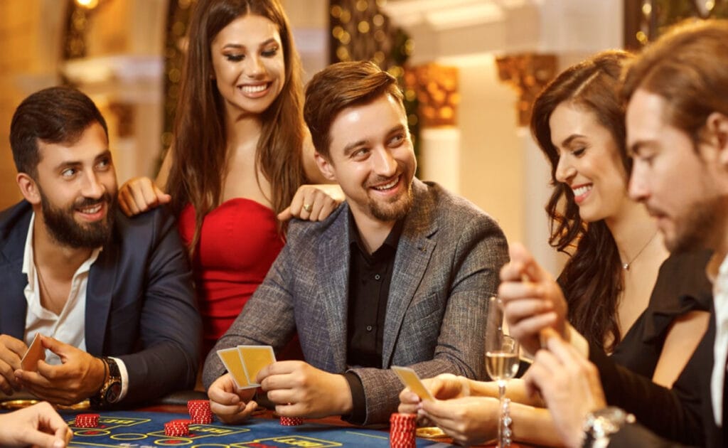 A group of people smiling and having a good time while playing a casino game.