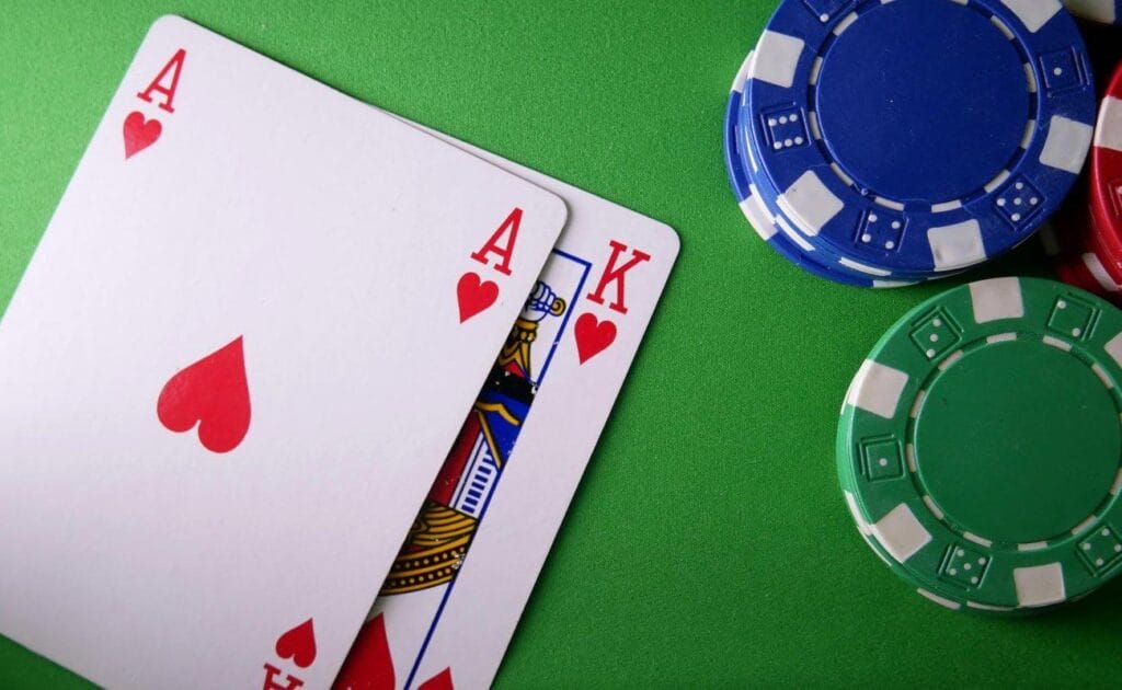 An ace and king of hearts next to several small stacks of poker chips.