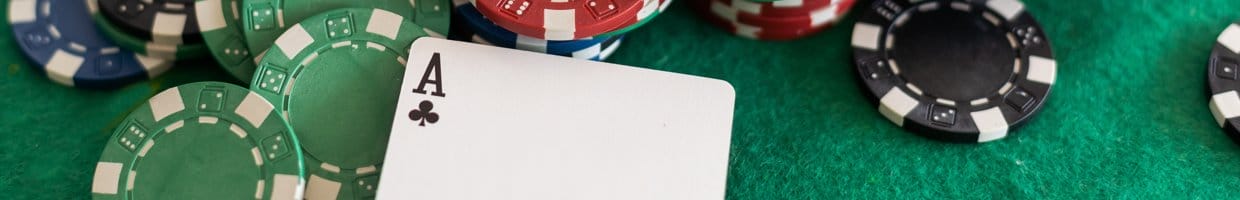 An ace sitting next to scattered poker chips.