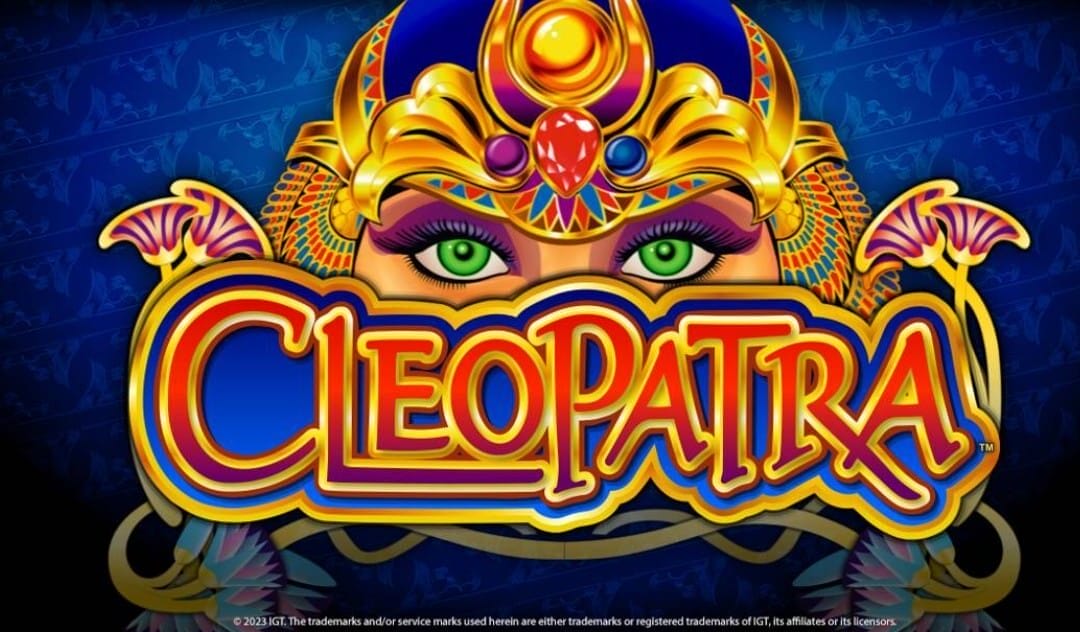 The banner for the Cleopatra slot game. The banner is set against a dark blue background featuring subtle, repeated hieroglyphic patterns. The foreground prominently features the stylized text Cleopatra in vibrant shades of gold, orange, red, and blue, with intricate detailing around each letter. Above the title, the illustration shows Cleopatra's eyes and ornate headdress decorated with jewels and intricate gold patterns, emphasizing a luxurious and exotic Egyptian theme.