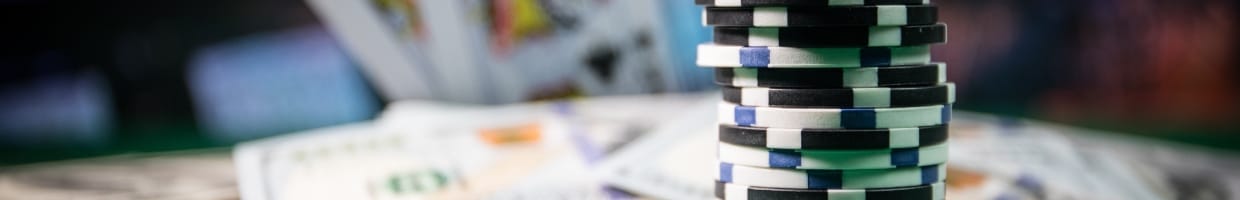Casino chips, money and playing cards on a table.
