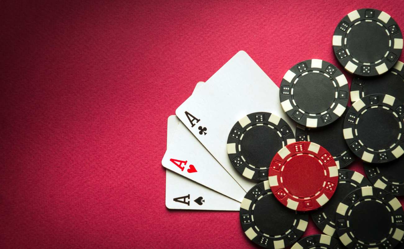  Ace playing cards and casino chips on a red felt table. 