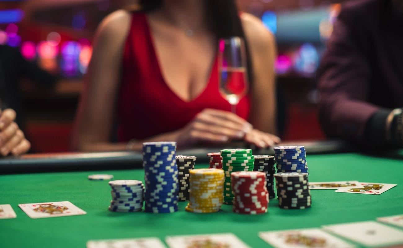 Stacks of different color poker chips, placed in the middle of the poker table, and playing cards arranged around the table. 