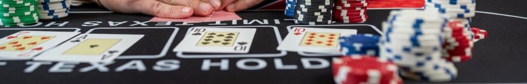 Black felt blackjack table with cards and poker chips scattered around.