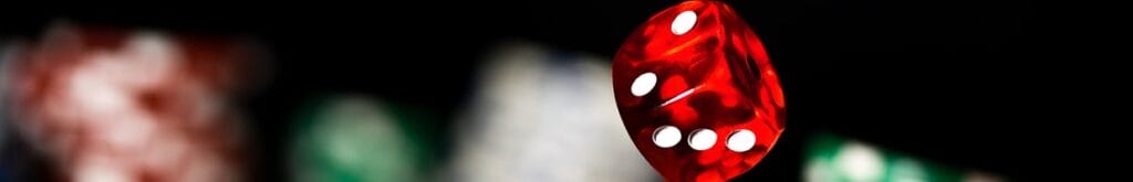 A close-up of dice landing on a casino table.