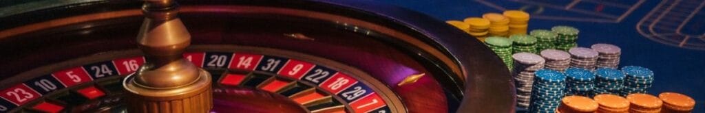 A closeup of a roulette wheel, and stacks of casino chips.