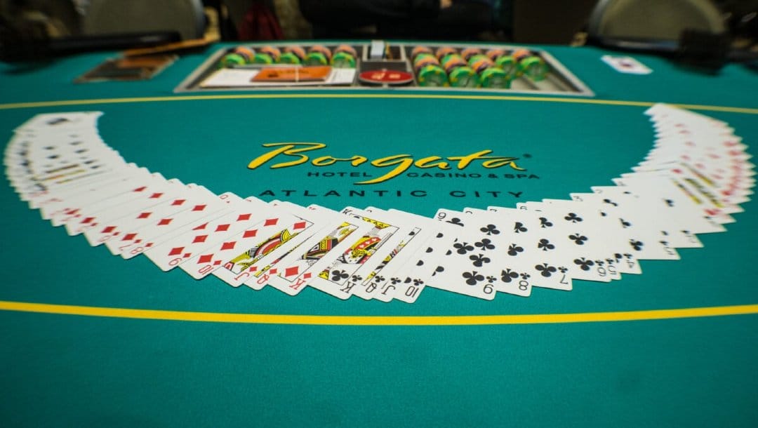 A poker table with the cards evenly spread in a half circle