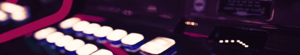 A slot machine at a casino with white buttons and a slot machine screen.